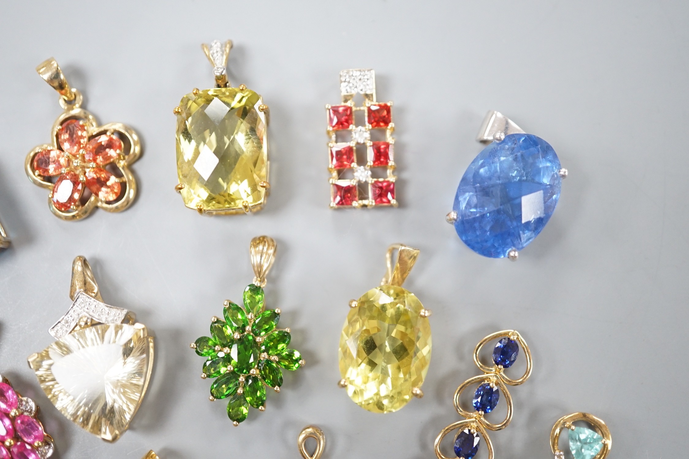 Nineteen assorted modern 9ct gold or yellow metal and gem set pendants, including citrine and amethyst and a 9ct gold chain, gross weight 63.6 grams.